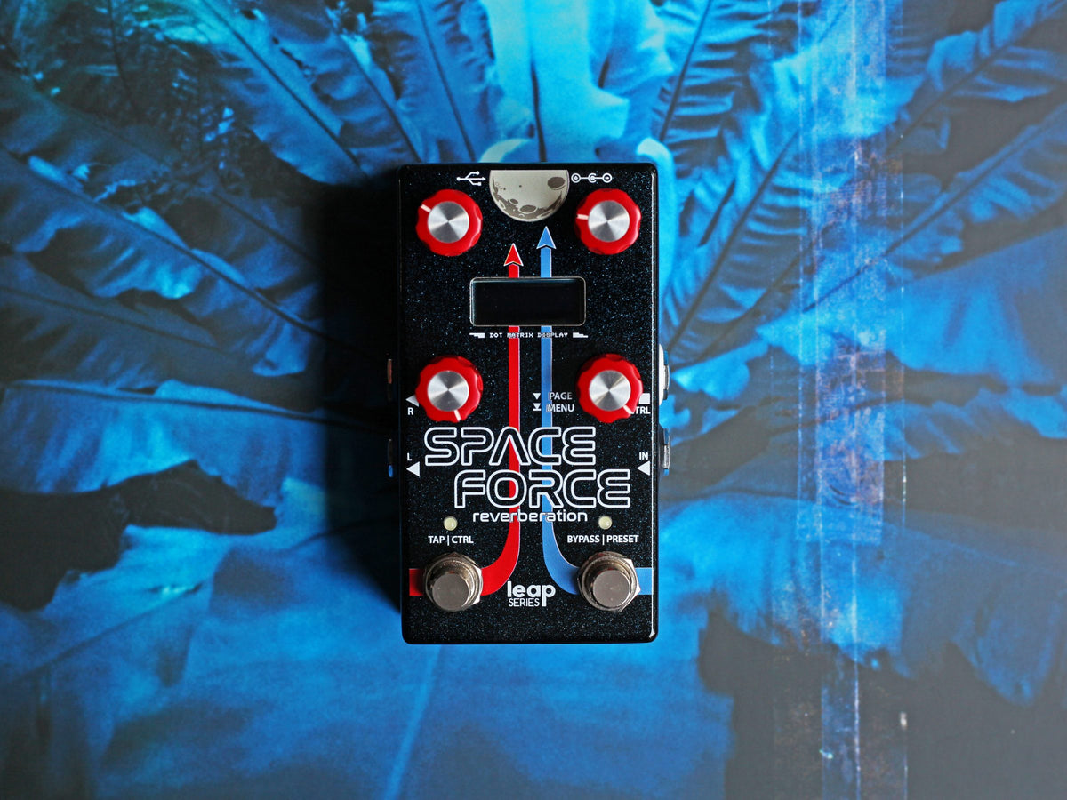 Pedal Alexander Space Force, negro con perillas rojas, sobre hojas azules