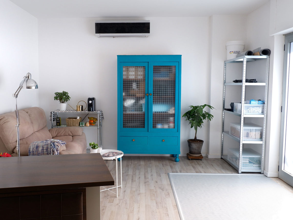 Sala del taller de Clatters Machines, con un sofá y un mueble azul