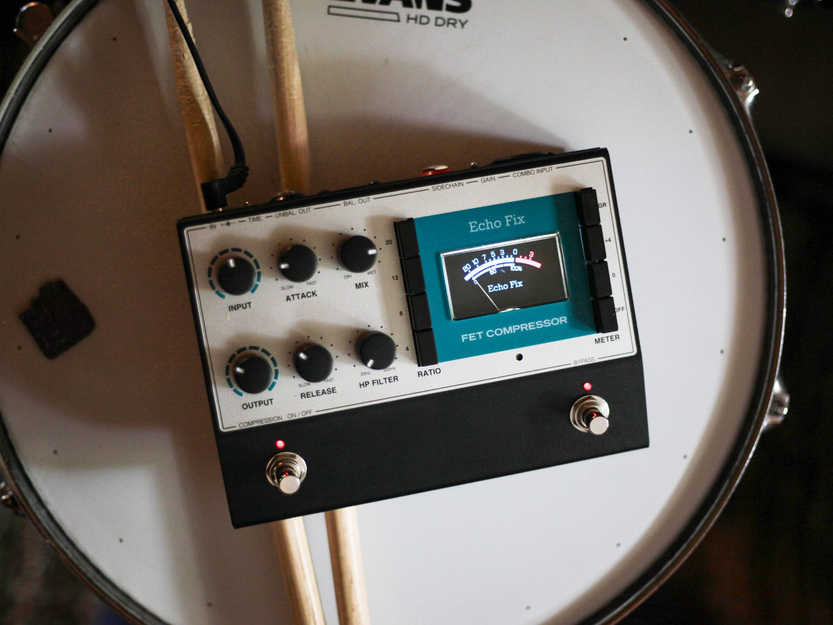 Pedal Echo Fix EF-P5 FET Compressor sobre el parche de un tambor, con baquetas