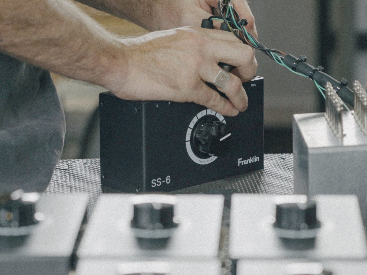 Manos conectando cables al Franklin SS-6 MKII sobre una mesa con pedales