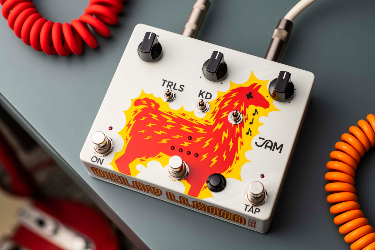 JAM Pedals Delay Llama XTREME sobre una superficie gris con un cable rojo en espiral