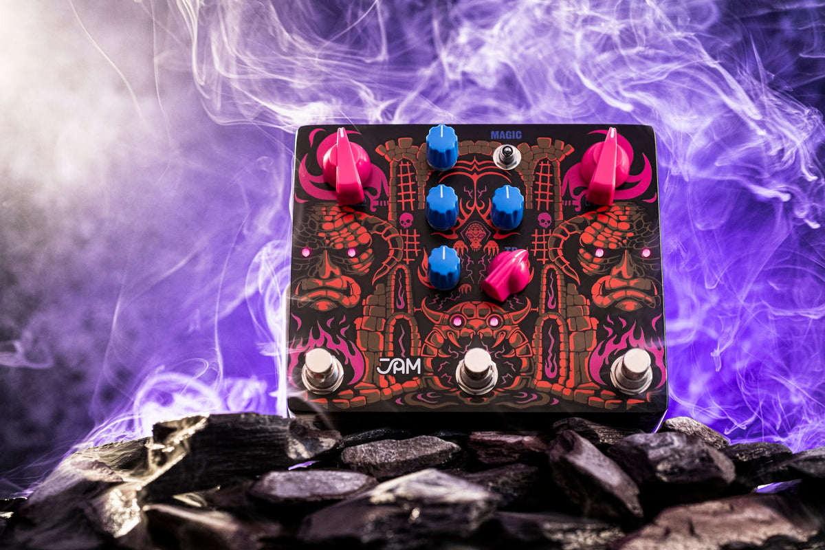 JAM Pedals Tiny Amp Destroyer sobre piedras con humo y luz violeta de fondo