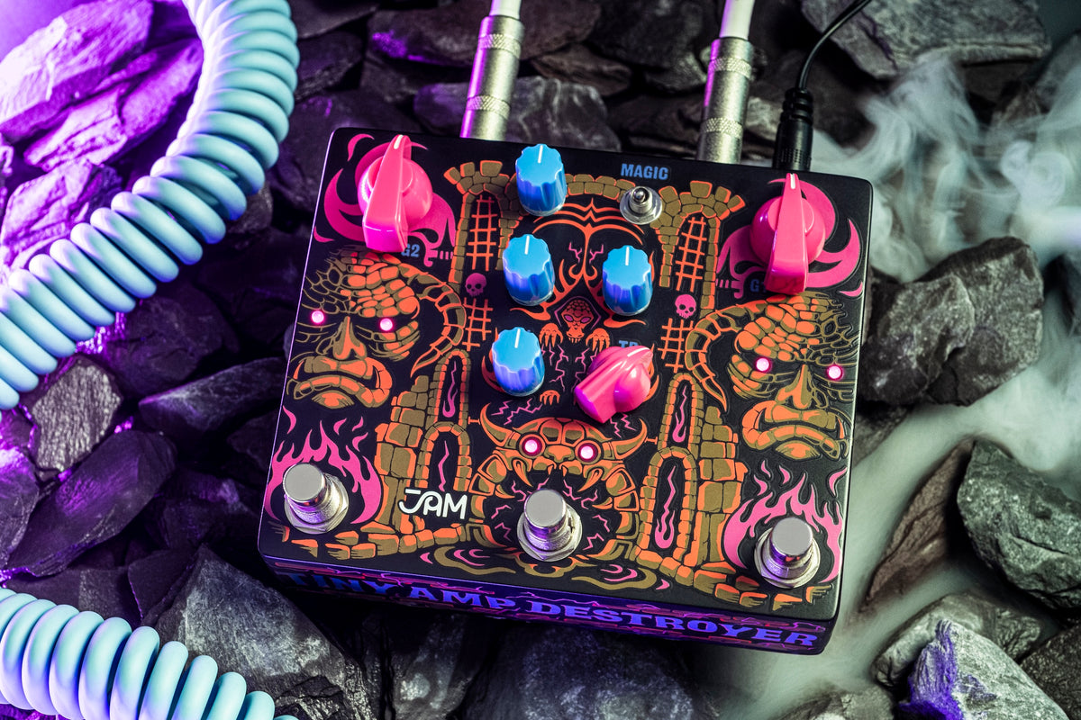 JAM Pedals Tiny Amp Destroyer conectado con cable en espiral sobre piedras