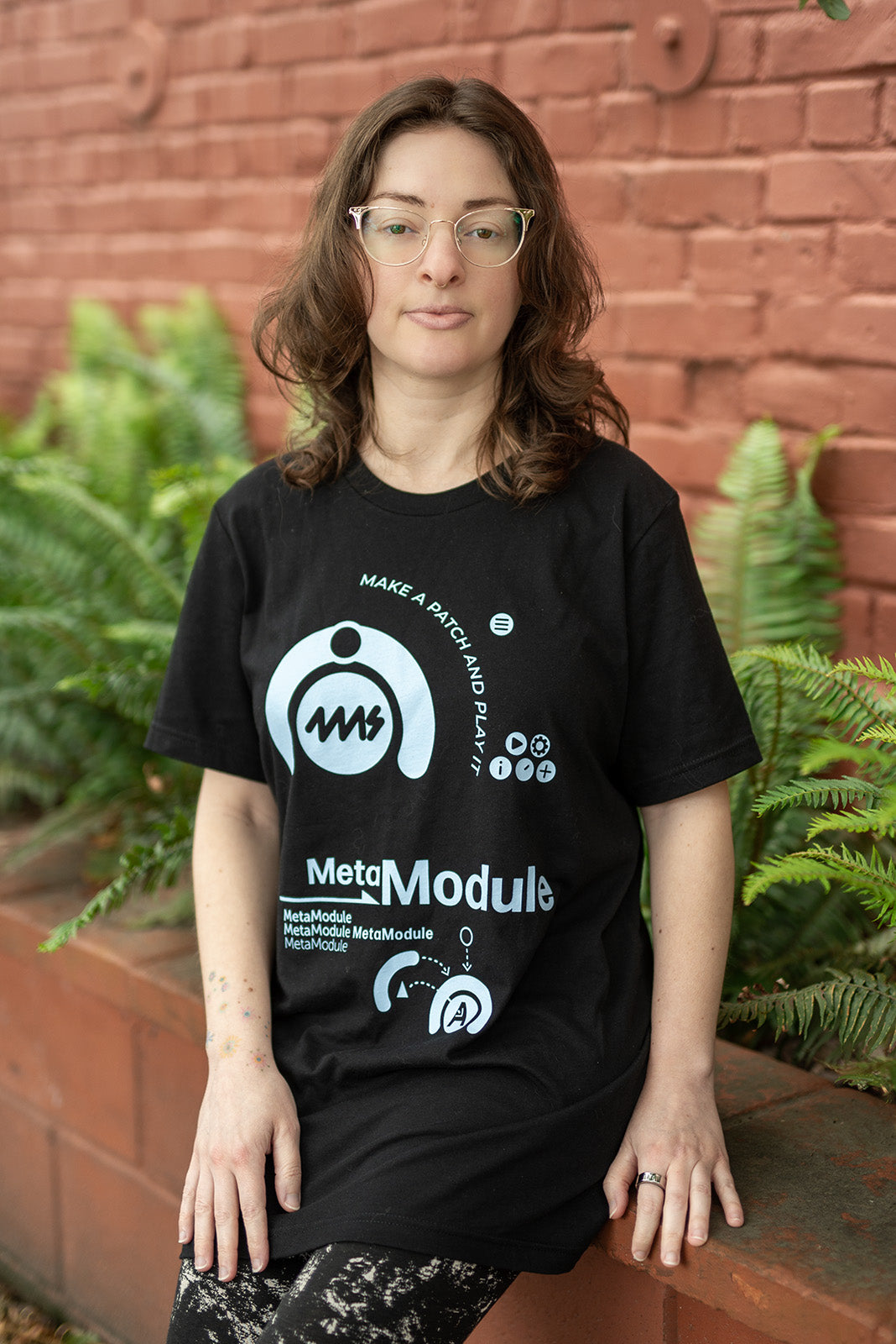 Persona usando la polera negra 4ms MetaModule con estampado celeste