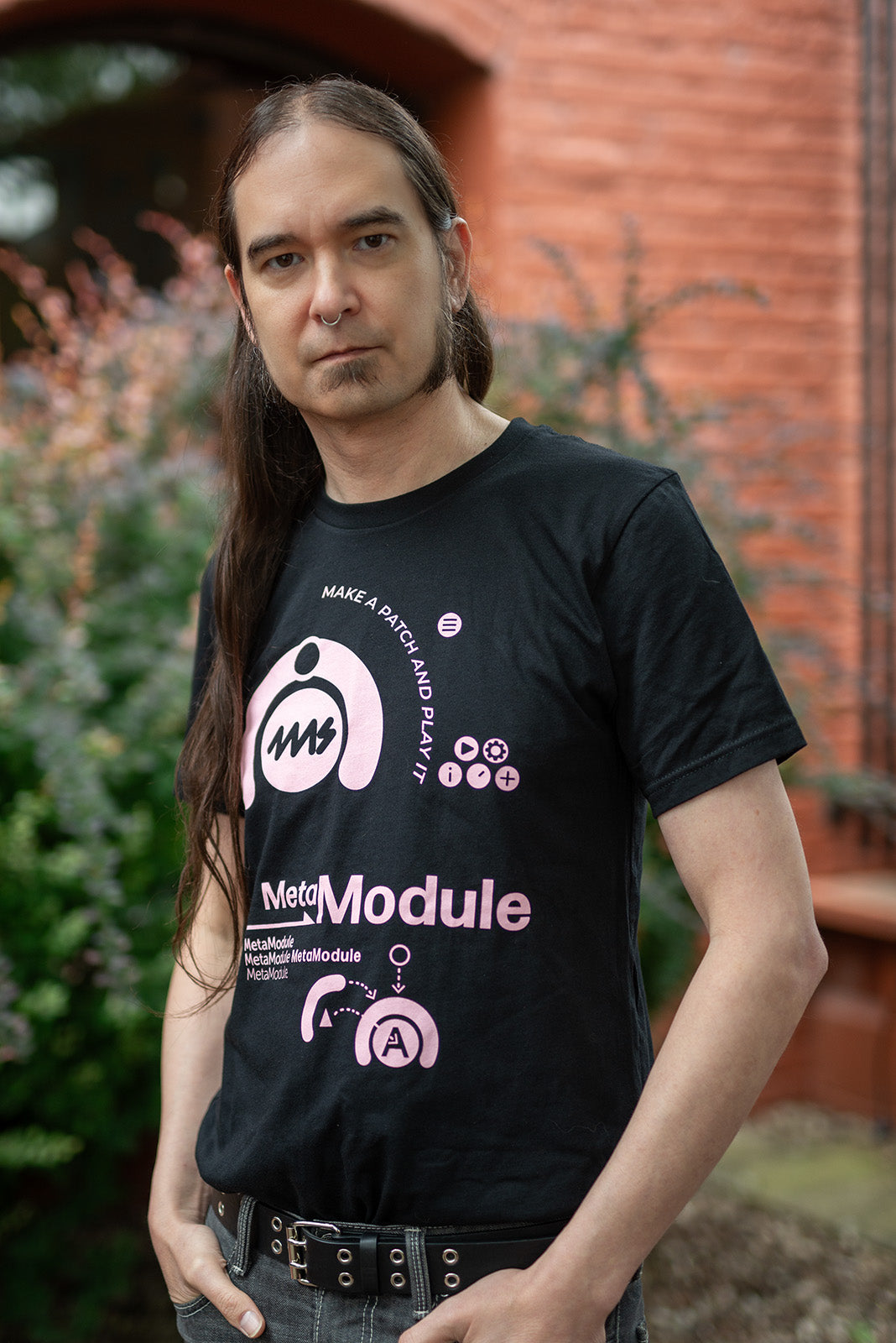 Persona usando la polera negra 4ms MetaModule con estampado rosado