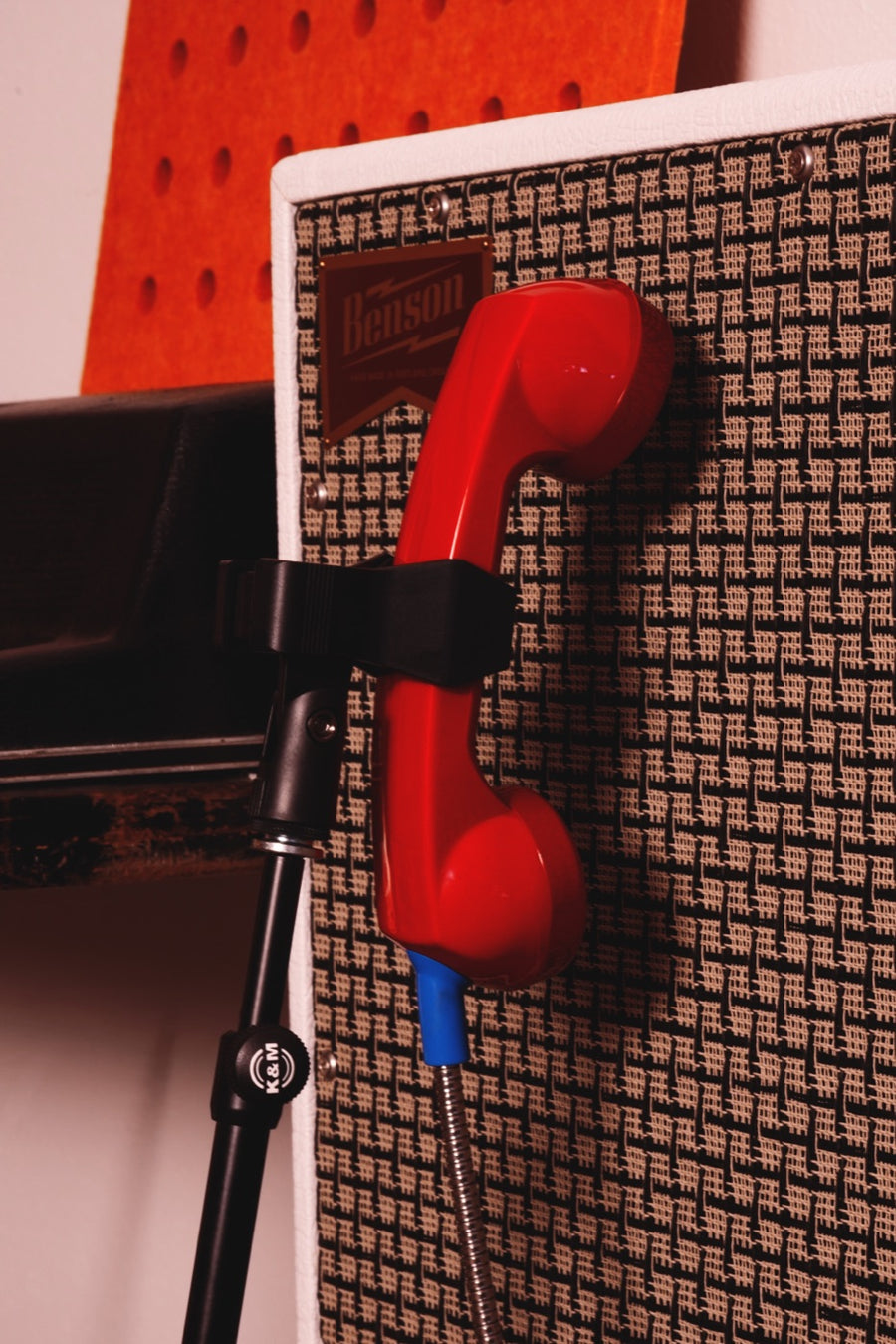 La unidad roja amarrada al pie frente a un Benson: el montaje típico para tomar un amplificador de guitarra.